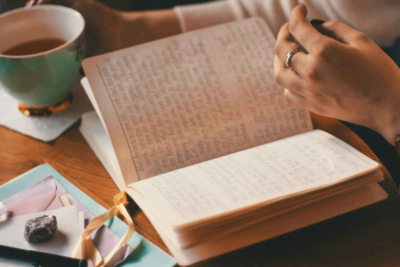 Herbal tea, notebook, gems on a wooden table– digital detox morning routine idea